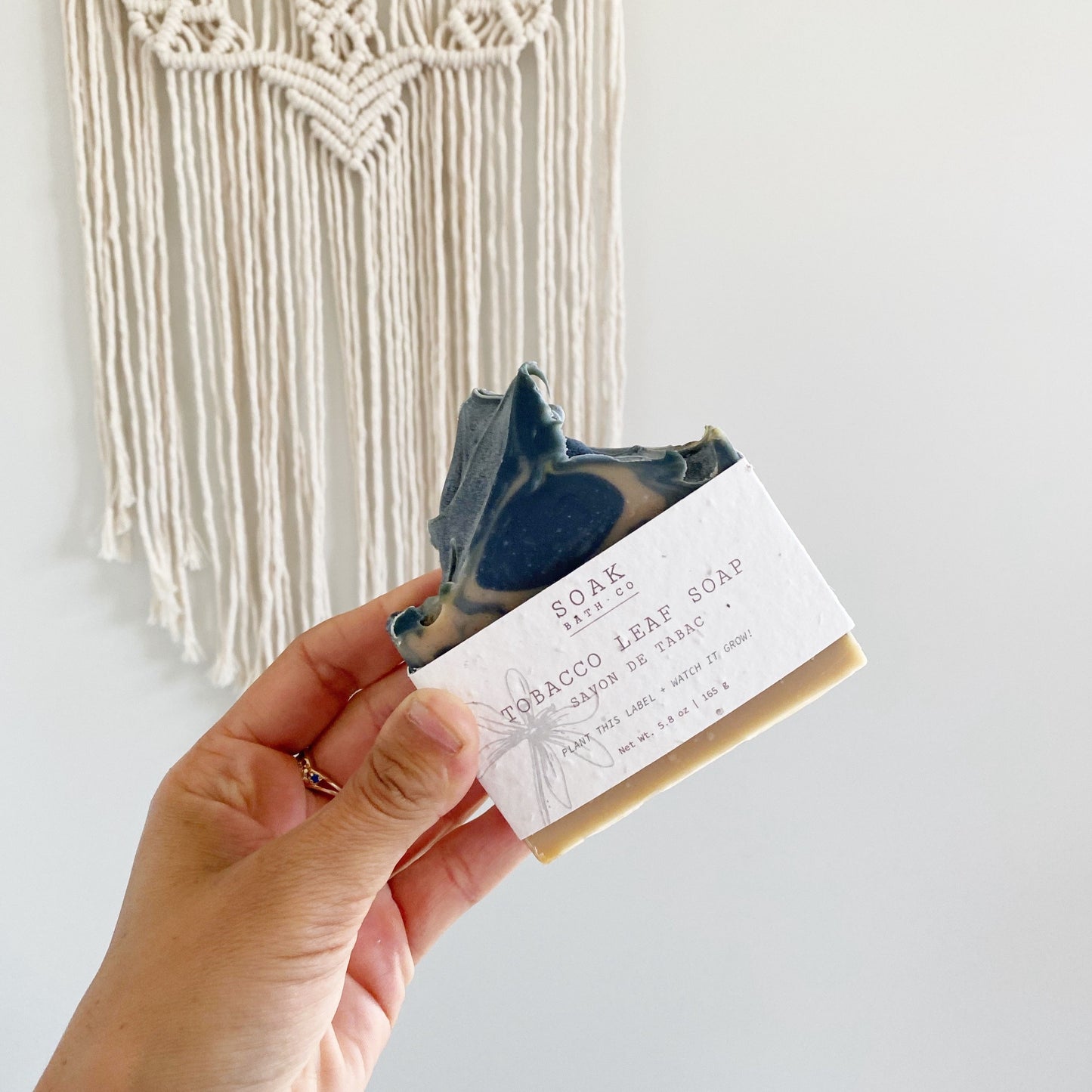 Tobacco Leaf Soap bar being held up in front of a handmade macrame