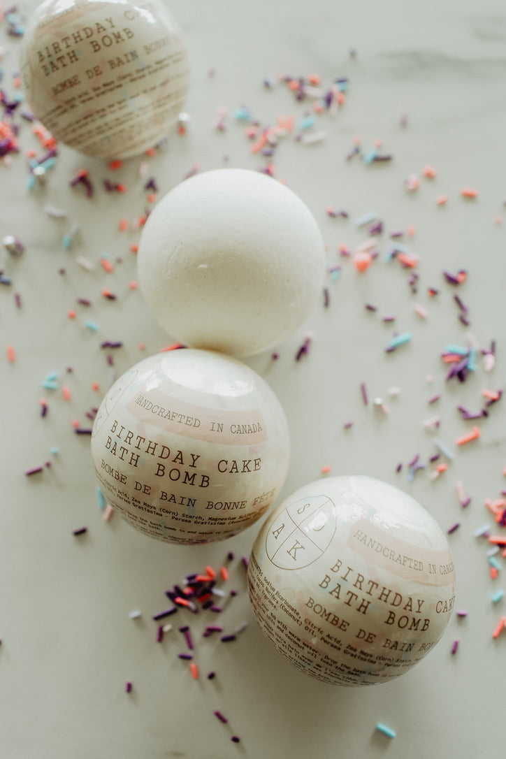 Three birthday cake bath bombs with sprinkles on a light background