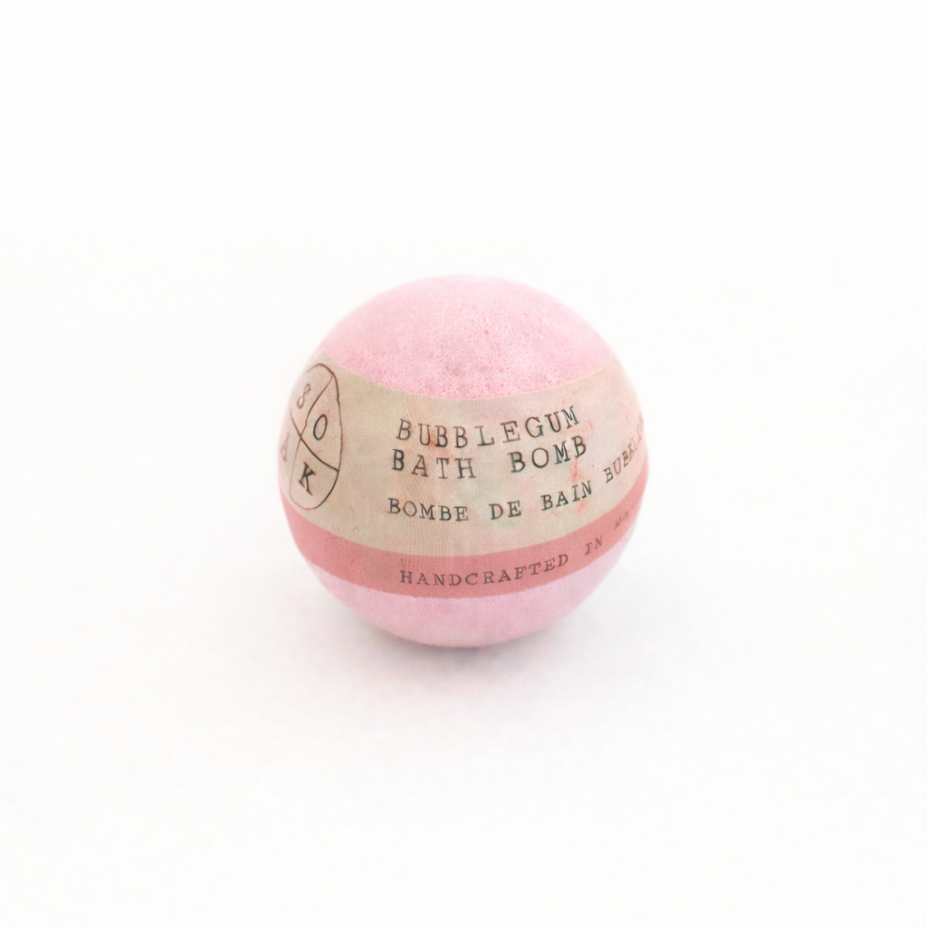 Pink bubblegum bath bomb with a label on a white background
