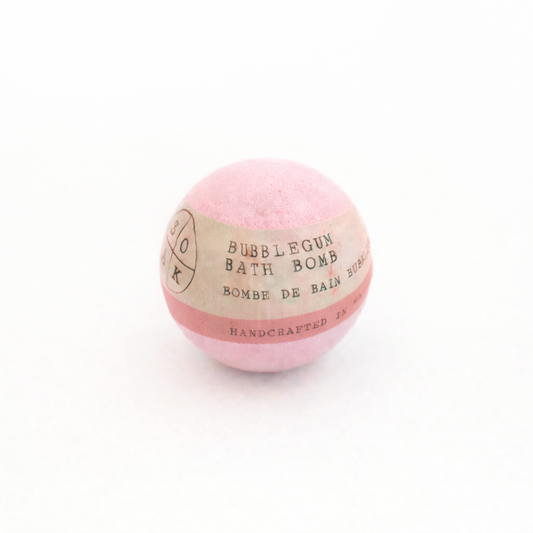 Pink bubblegum bath bomb with a label on a white background