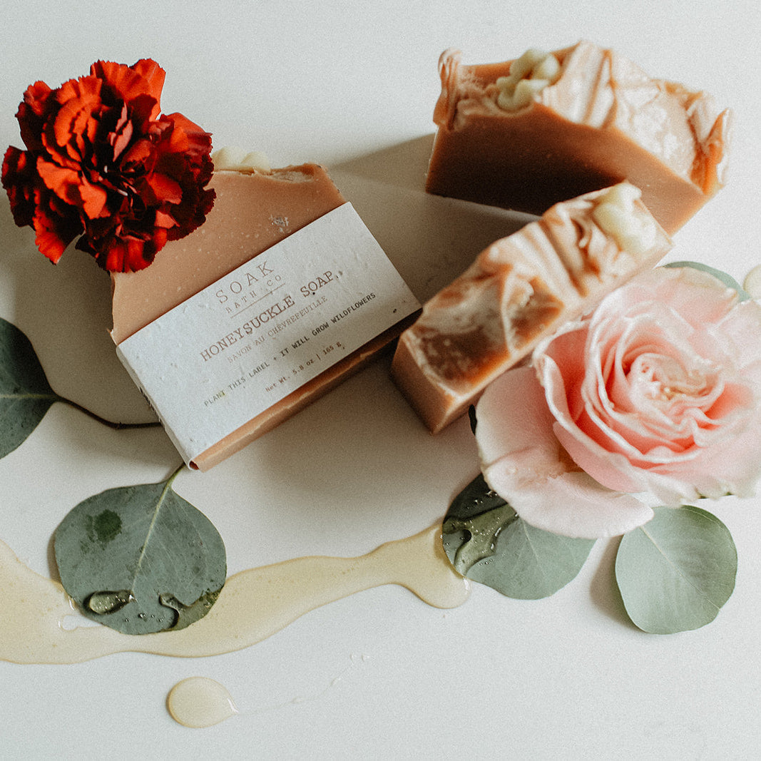 Three bars of soap with floral decorations on a light surface