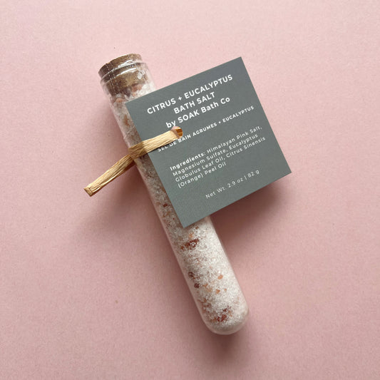 Bath salt in a glass container with a label on a pink background