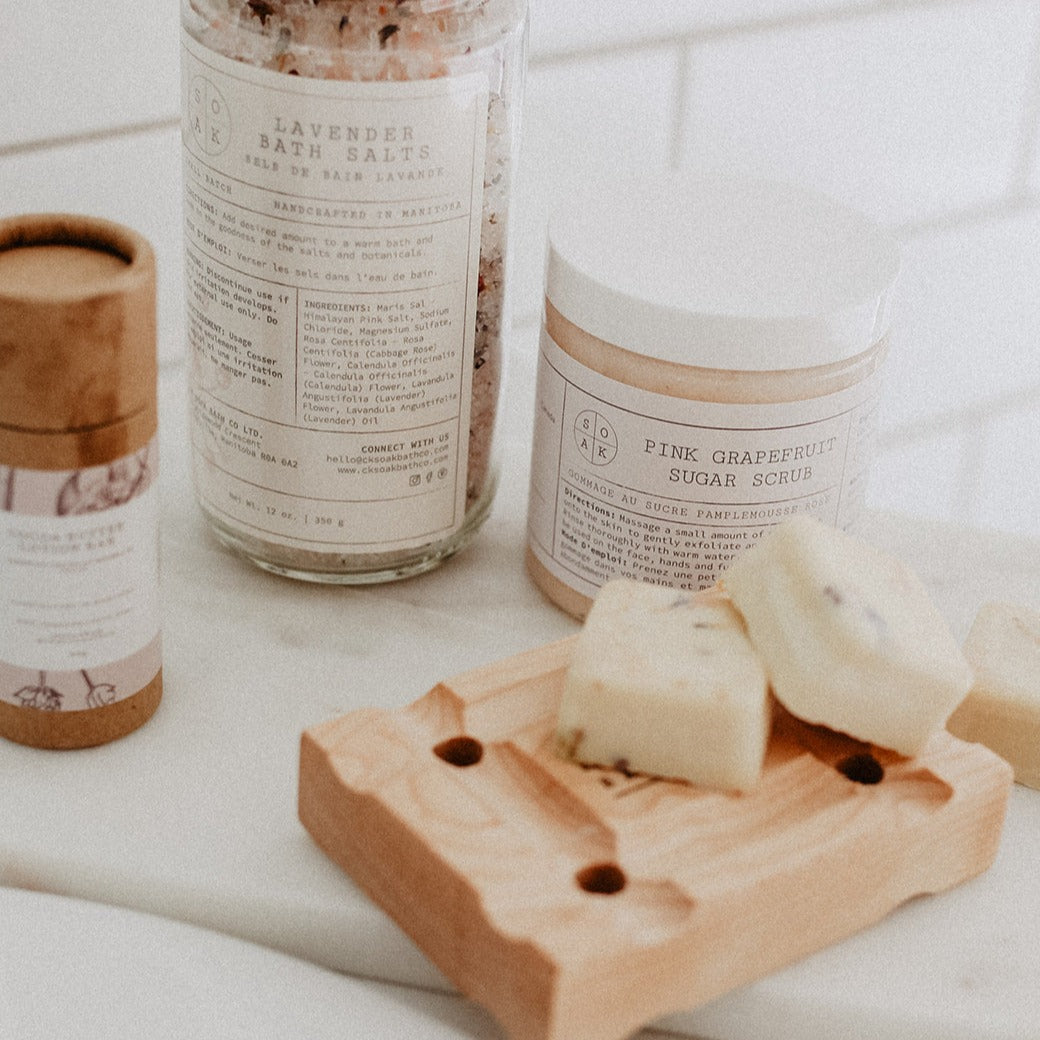 Self Care essentials by SOAK Bath Co including Pink Grapefruit Sugar Scrub, Bath Salt Soaks and Cocoa Butter Lotion Bar