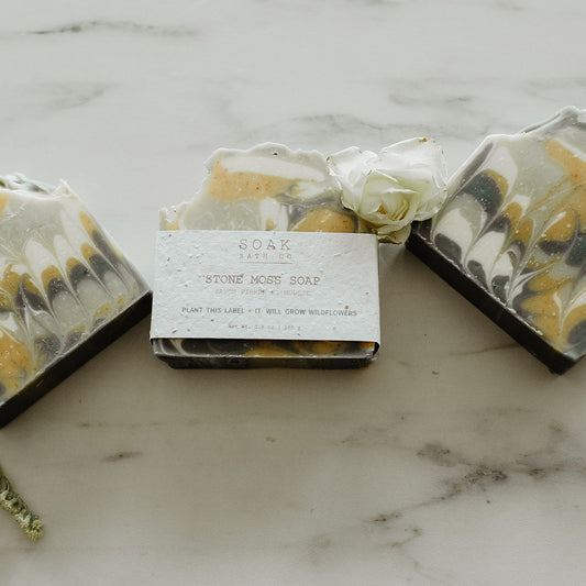 Three bars of soap with marbled design on a marble surface