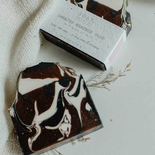 Two marbled soap bars on a textured surface with a white label.