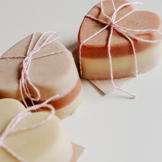 Heart-shaped soap bars wrapped with string on a light background