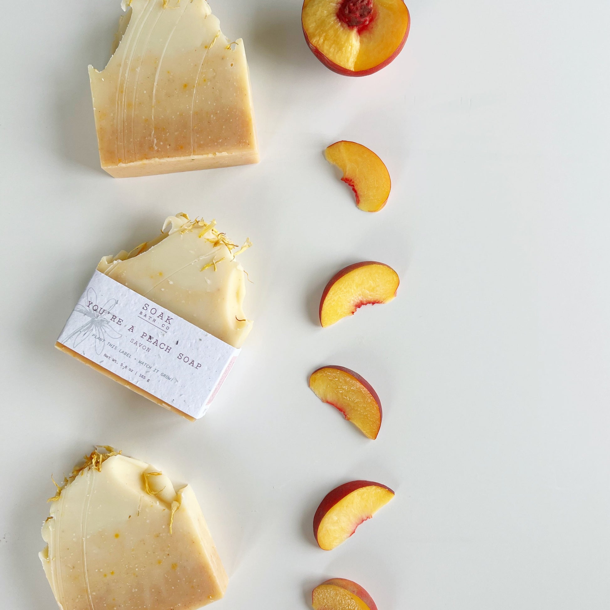 handmade soap bars scented with peach surrounded by peach slices
